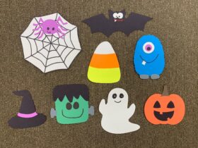 An image of the spooky scavenger hunt pieces made with construction paper. There is a spider web, a bat, candy corn, a friendly monster, a witch's hat, Frankenstein's monster, a ghost, and a Jack-o'-lantern.