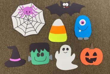 An image of the spooky scavenger hunt pieces made with construction paper. There is a spider web, a bat, candy corn, a friendly monster, a witch's hat, Frankenstein's monster, a ghost, and a Jack-o'-lantern.