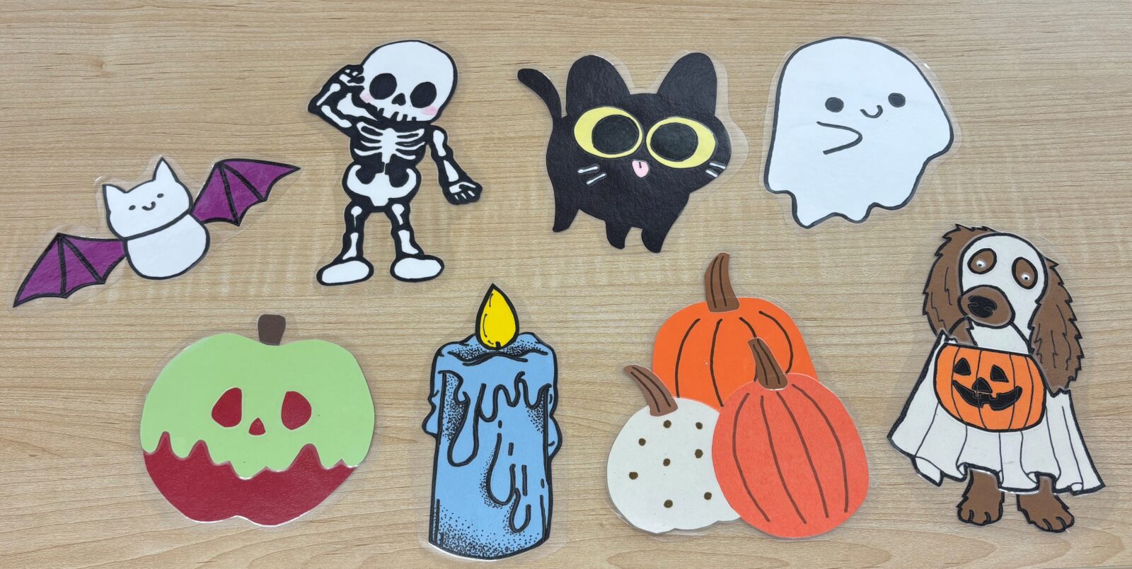 8 spooky scavenger hunt items. A bat, a skeleton, a black cat, a ghost, a poison apple, a melting wax candle, three pumpkins together, and a dog in costume.