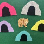 Bear made of felt surrounded by different colored felt caves