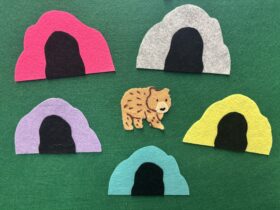 Bear made of felt surrounded by different colored felt caves